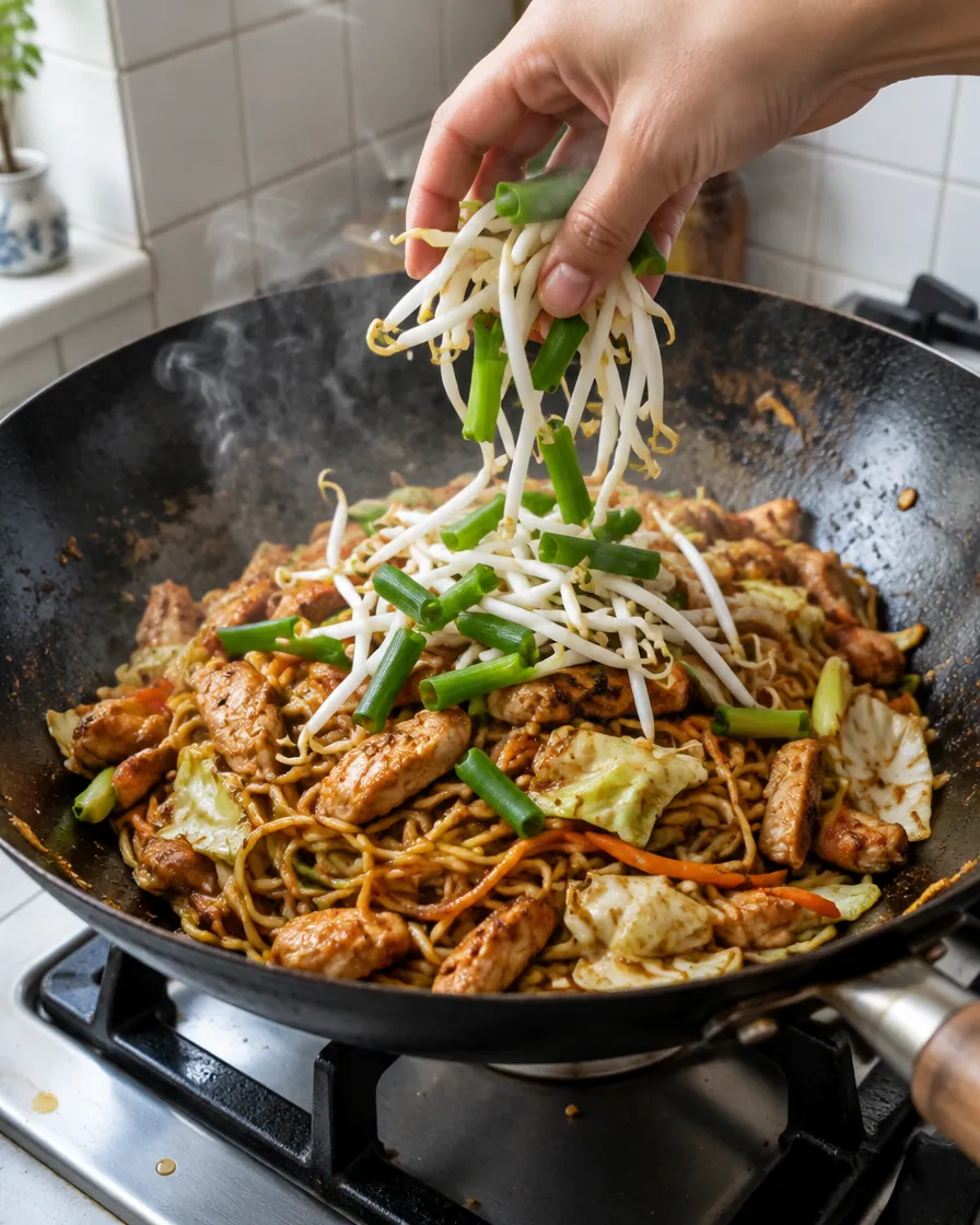 Step 9: Add the bean sprouts and the green parts of the onions and t