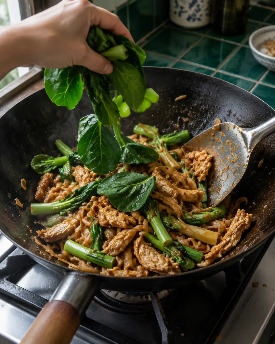 Step 6: Throw in the broccoli leaves, toss through, and take the pan
